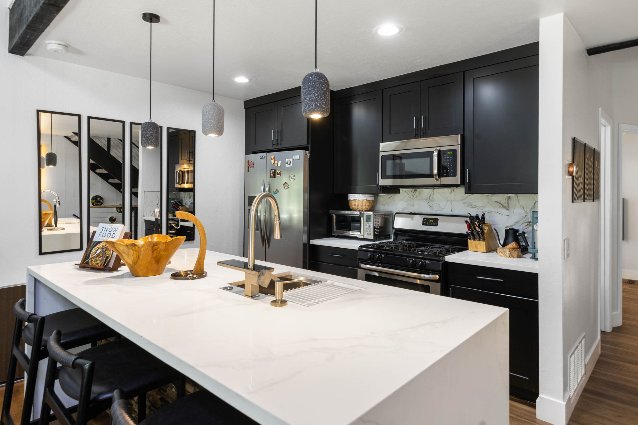 Cubs Manor: black kitchen with quartz island