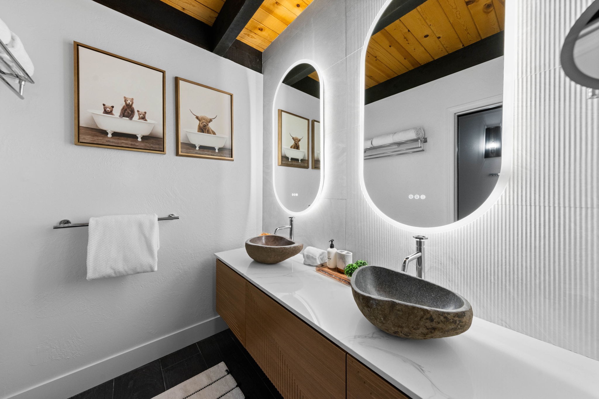 Cubs Manor: double stone vessel vanity with backlit mirrors after renovation