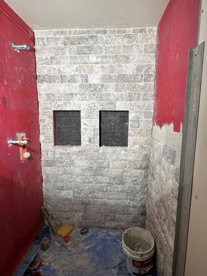 Muro de piedra de la ducha en instalación